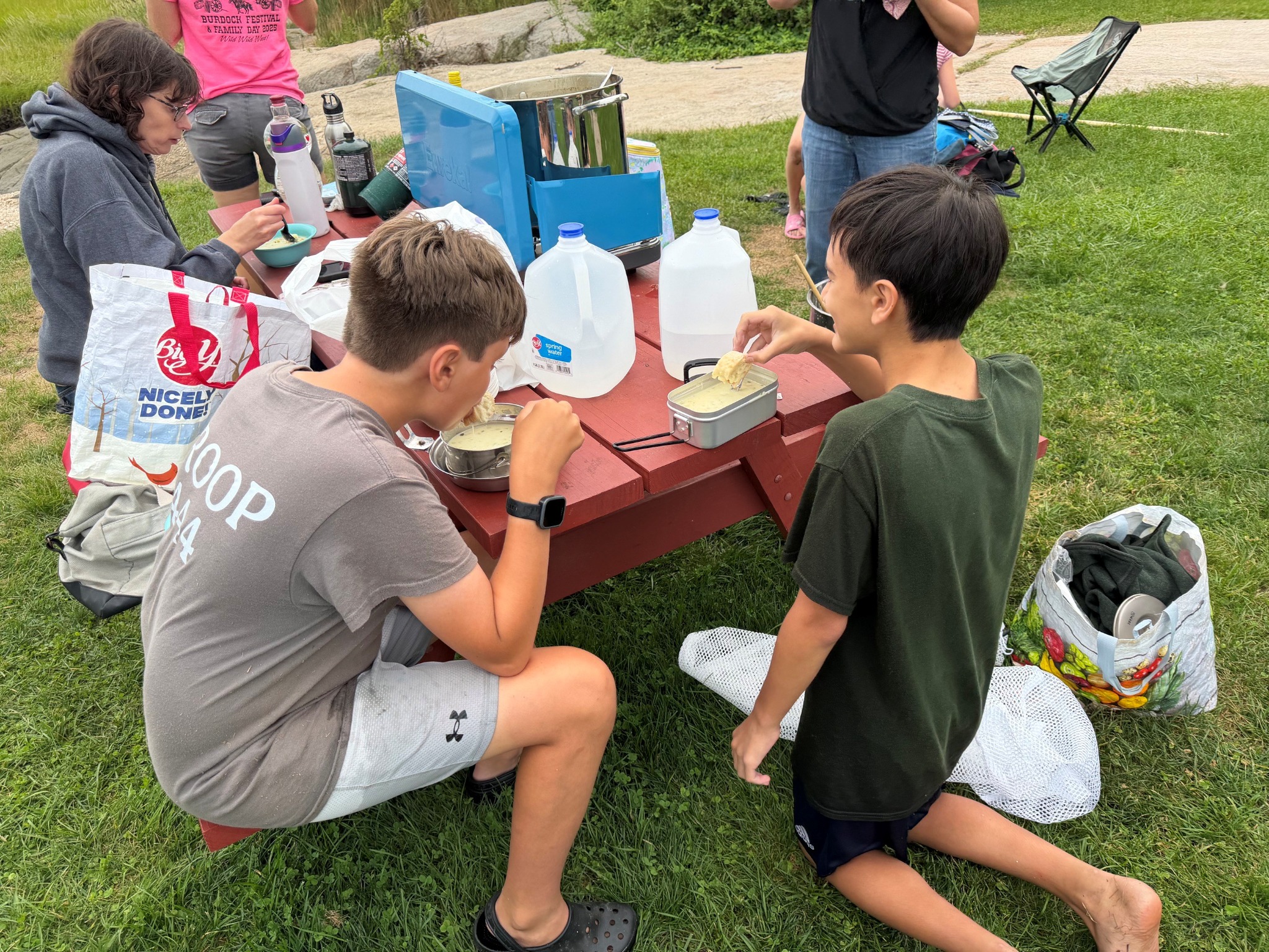 Scouts eating chowder outdoors during the 2026 clamming trip.